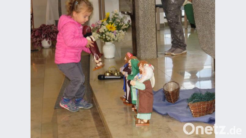 Mit Puppen und einem blauen Tuch stellen die Kinder symbolisch die Suche Jesu nach Aposteln dar. Bild: adj