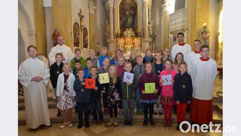 Mit bunten Buchstaben definierten die neuen Ministranten ihren Altardienst. Pastoralreferent Maximilian Pravida und Kaplan Ulrich Eigendorf (von links) versprachen die Minis ihren Dienst sorgfältig und ehrfürchtig zu verrichten. Bild: dob