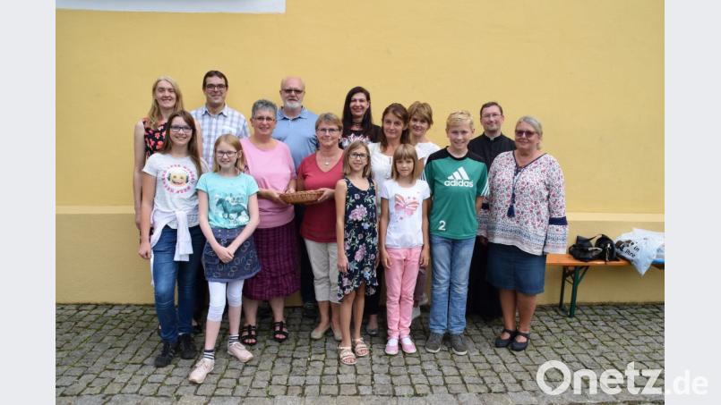 Chorleiterin Maria Birner überreicht zusammen mit einem Teil des Chores sowie Kirchenpflegerin Susanne Lindner (hinten links) und Pfarrvikar Christian Preitschaft (hinten rechts) den Erlös aus dem Kirchenkonzert in Höhe von 603 Euro an die Vertreterin des Kinderpalliativteams Ostbayern, Lydia Moosburger (Mitte). Bild: swo