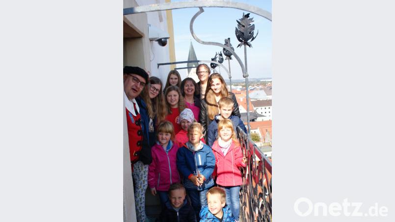 Auf dem Turm der Weidener Michaelskirche spielen Mitglieder des Posaunenchors Mantel Choräle, und die Kinder hören gespannt den Erzählungen von Türmer Christian Stahl zu. Bild: sei