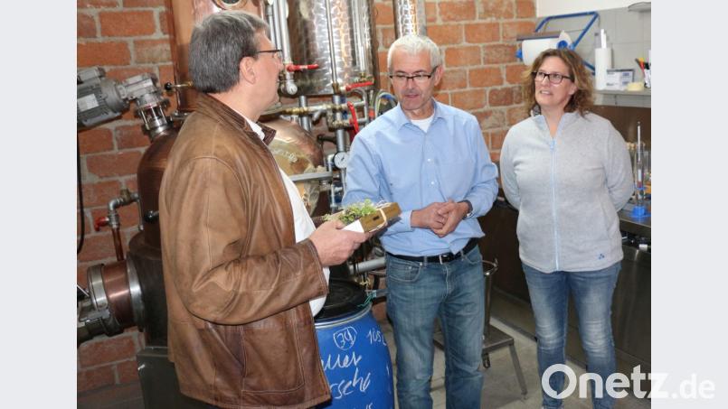 Der Vorsitzende des Obst- und Gartenbauvereins, Josef Häckl, bedankt sich beim Ehepaar Norbert und Sabine Pühl mit echten Kemnather „Pflastersteinen“ für die Führung. Bild: rpp