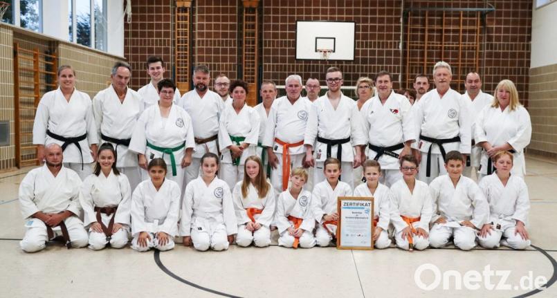 Die Karatekas präsentieren stolz das Qualitätszertifikat, das der Präsident des Deutschen Karate Verbands (DKV) Wolfgang Weigert (mittlere Reihe, Dritter von rechts) den Vohenstraußer Sportlern verleiht. Dojo-Leiter Marcel Bieber (mittlere Reihe, Vierter von rechts) nimmt die Auszeichnung entgegen. Bild: dob