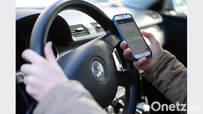 So ist's keinesfalls erlaubt: Die Hände gehören ans Steuer. Bild: Monika Skolimowska/dpa