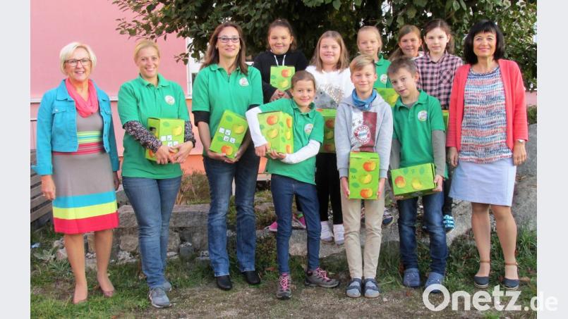 100 Liter frisch gepressten Apfelsaft übergeben die „Flötztaler Naturentdecker“ an Grundschulrektorin Gudrun Lehner (links) und ihre Stellvertreterin Lucia Etterer (rechts). Bild: mez