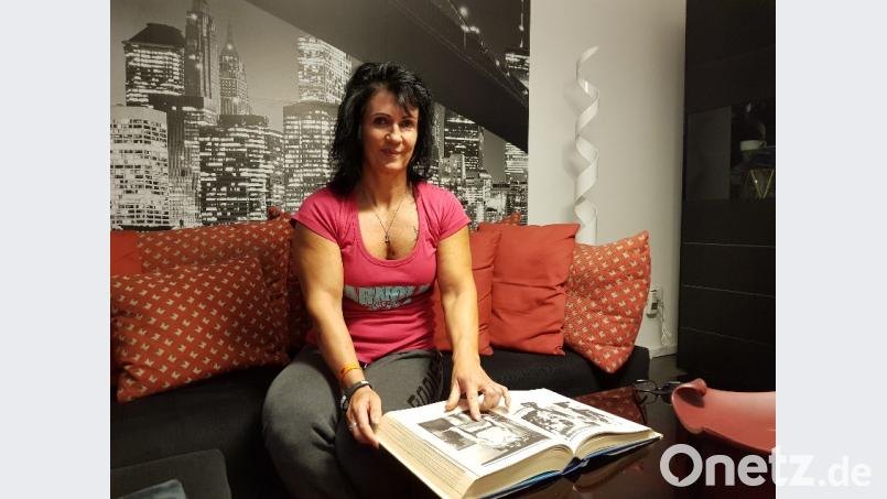 Irene Maas mit einem Schwarzenegger-Buch in ihrem Wohnzimmer. Beim Training orientiert sich die Sulzbacher Sportlerin auch an den Empfehlungen der Bodybuilding-Legende. Bild: Tobias Gräf