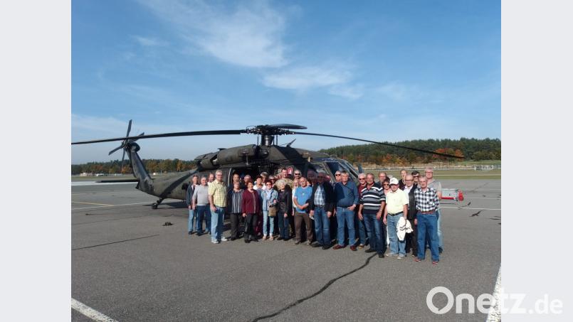 Die Mitglieder des Kirchenthumbacher Rentner- und Pensionistenvereins unterbrechen die Lagerrundfahrt durch den Grafenwöhrer Truppenübungsplatz, um sich vor einem Hubschrauber zu einem Erinnerungsfoto aufzustellen. Bild: gpa