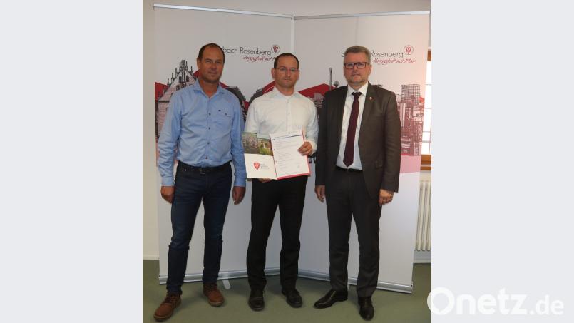 Bürgermeister Michael Göth (rechts) und Roland Maul (links) gratulieren Achim Fischer zum Meisterbrief als Bestatter. Bild: mfh