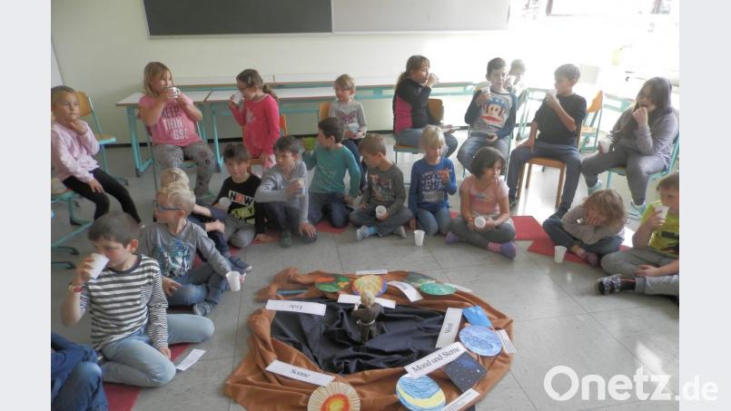 Nachdem sie das Bodenbild vervollständigt haben, lassen sich die Schüler den Apfelsaft schmecken. Bild: ak