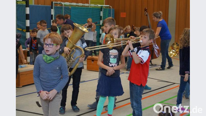Mit großer Begeisterung probieren die Grundschüler die Instrumente aus und versuchen unter anderem Posaune und Tuba Töne zu entlocken. Bild: du