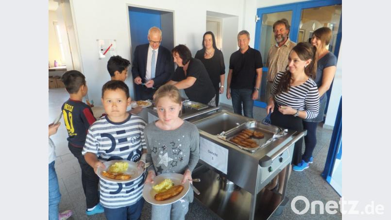 Zufrieden zeigen sich Bürgermeister Bernhard Lindner, Christine Ebensberger (Kolping), Kämmerin Sabine Wilde, Konrektor Stefan Ottmann, Rektor Heinz Meinl, Julia Walter (Kolping) und Lehrerin Kerstin Arnold (von links) bei der Essensausgabe. Bild: ibj