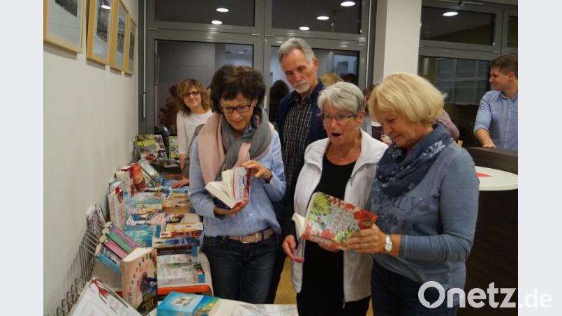 Bei lockerer Unterhaltung und in angenehmer Atmosphäre bei einem Gläschen Wein begutachten die Besucher der Mondschein-Ausleihe in der Gemeindebücherei vor allem die neuesten Romane und Jugendbücher. Bild: du