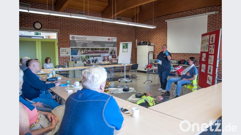 Der Verbandskasten im Auto enthält viele wertvolle Materialien. Helmut Richter stellt sich für die Präsentation verschiedener Verbandtechniken zur Verfügung. Kursleiterin Silke Kunz (stehend) erklärt bei dem Angebot des Roten Kreuzes Erste-Hilfe-Maßnahmen. Bild: cfd