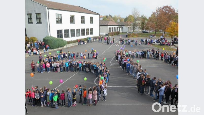 Am Ende des Schulfestes formieren sich die Grund- und Mittelschüler auf dem Pausenhof zur Zahl 50 und lassen bunte Luftballons in die Luft steigen. Bild: jzk