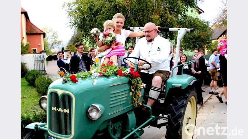 Auf dem festlich geschmückten Traktor macht sich das frisch vermählte Brautpaar mit Töchterchen Antonia auf den Weg zum Kirchenreinbacher Gasthaus Goldene Krone, wo die Hochzeitsfeier ihre Fortsetzung nimmt. Bild: ds