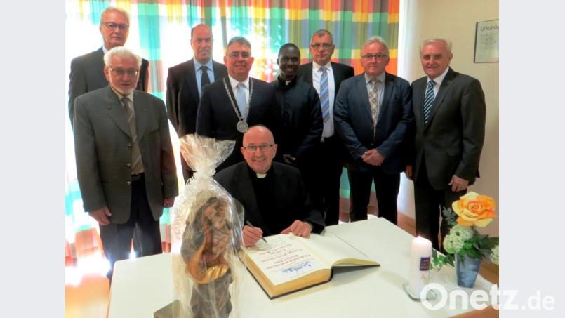 Pfarrer Bernhard Huber (vorn) trägt sich ins Goldene Buch der Marktgemeinde Freihung ein (von links): Georg Schirbl, Max Biller, Bernd Lehner,
Bürgermeister Norbert Bücherl, Pfarrvikar David Lubuulwa,
Georg Fritsche, Wolfgang Harrer und Zweiter Bürgermeister Helmut Klier Bild: Manfred Fritsche