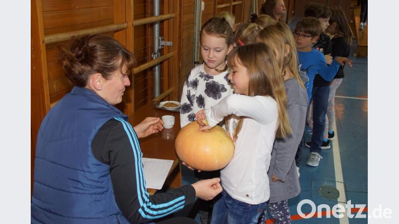 Wie schwer ist der Kürbis? Nicht einfach für die Kinder, das Gewicht dieser Gartenfrucht zu erraten. Bild: mmj