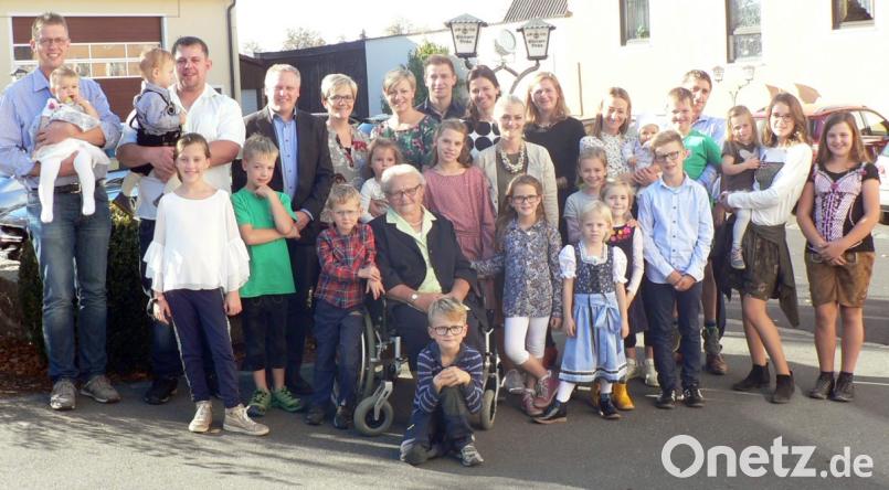 Stolz auf ihre große Familie ist Apollonia Friedl (sitzend) an ihrem 90. Geburtstag: 20 Urenkel, 11 Enkel sowie Kinder und Schwiegerkinder gratulieren ihr herzlich. Für die Marktgemeinde überbringt Bürgermeister Jürgen Kürzinger (Dritter von links) Glückwünsche, von der Pfarrgemeinde kommt Pater Samuel Patton zur Feier. Bild: lep