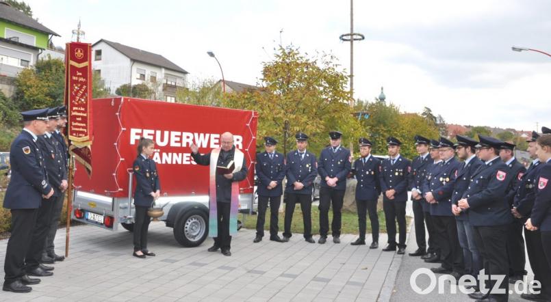 Pfarrer Wilhelm Bauer segnet vor dem Feuerwehrhaus den neuen Feuerwehr-Anhänger. Bild: es