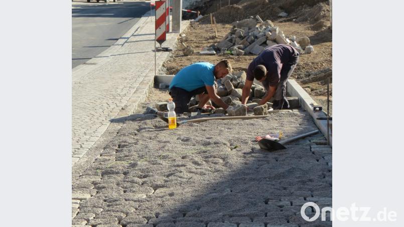 Auch bei den Pflasterarbeiten ist bald ein Ende in Sicht. Hier legen die zwei Bauarbeiter gerade einen Parkplatz beim Pfarrheim an. Bild: kö