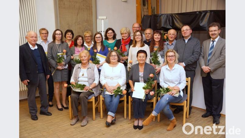 Von Bischof Rudolf Voderholzer signierte Dankurkunden in Silber geben Dekanatskirchenmusiker Berthold Stahl und Pfarrer Markus Bruckner (von rechts) an Laura Kreuzer, Stefanie Wöhrl, Maria Lautner, Lydia Fröhlich, Gerda Ogermann, Judith Sollfrank, Stefanie Vetter, Christine Spörrer, Siegfried Vetter, Christine Sollfrank, Günther Zwick, Gabi Scharf, Helmut Kotlar (hinten, von links) sowie Hedwig Bäuml, Inge Schraml, Irmgard Most und Tina Pöllath (sitzend von links) weiter. Volker Brandl (links) kündigt nach 40 Jahren seinen Rückzug als Chorleiter an, Bild: bkr