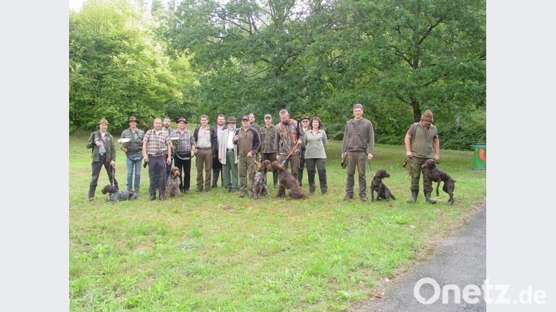 Hundeobmann Andreas Schiedlowsky und Vorsitzender Wolfgang Schinner (Siebter und Achter von links) gratulieren den Jägern zur bestandenen Prüfung ihrer Vierbeiner. Bild: hrö