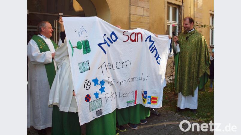 "Mia san Minis“ war auf der „Fahne“ der Ministranten aus Ebermannsdorf/Pittersberg zu lesen, die Pfarrer Gerhard Pöpperl (rechts) mit Pater Christian Liebenstein vorstellte. Bild: sön
