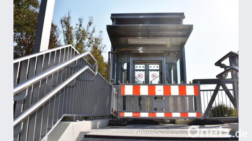 Ein rot-weißer Baustellenzaun steht vor den nagelneuen Glasaufzügen am Bahnhof. Die Inbetriebnahme durch die Deutsche Bahn verzögert sich weiter. Bild: lue