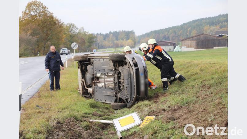 Seitlich im Graben landet der VW Golf. Helfer der Feuerwehr versuchen, das Auto wieder auf alle vier Räder zu bringen. Bild: jma