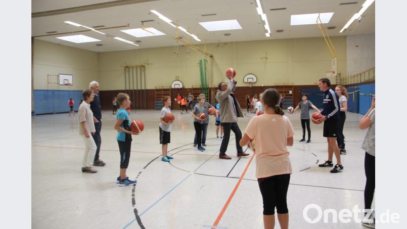 Als geschickter Basketballer zeigt sich Bürgermeister Franz Stahl beim Besuch der Schülergruppe. Christine Güntner und Hans-Albert Dahlheim vom Stiftland-Gymnasium (links) schauen interessiert zu. Bild: exb