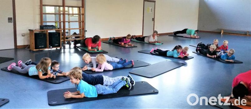 Was die Kinder leicht und lachend schaffen, bereitet den Mamis und Omis (am Bildrand) bei der Gymnastik schon manchmal Mühe. Bild: jml