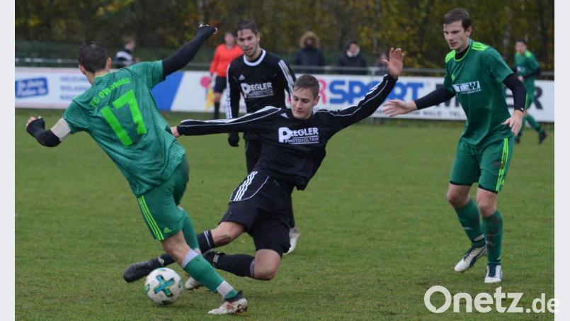 Manuel Löffelmann (links) vom FC OVI-Teunz im Zweikampf mit dem Schwarzhofener Christian Fischer. Löffelmanns Teamkollege Manfred Widegger (rechts) beobachtet die Szene. Der SV Schwarzhofen siegte mit 3:1. Bild: ham
