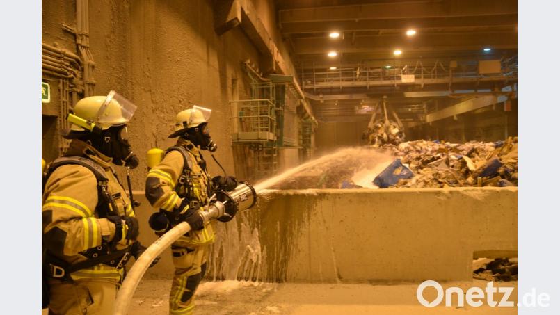 Mit schwerem Atemschutz und mit Schaumrohr waren die Feuerwehrler im Müllbunker zugange. Bild: Zweckverband Müllverwertung Schwandorf