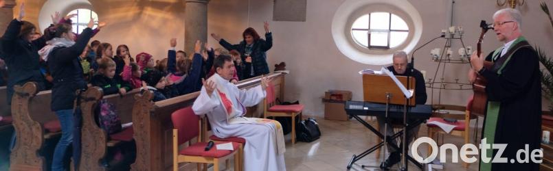 Freudig stimmen die Kinder bei der Abschlussandacht in das Lied „Einfach spitze, dass du da bist" ein. Pfarrer Wilfried Römischer mit der Gitarre und Kantor Andreas Kunz am Keyboard begleiten den Gesang. Bild: le