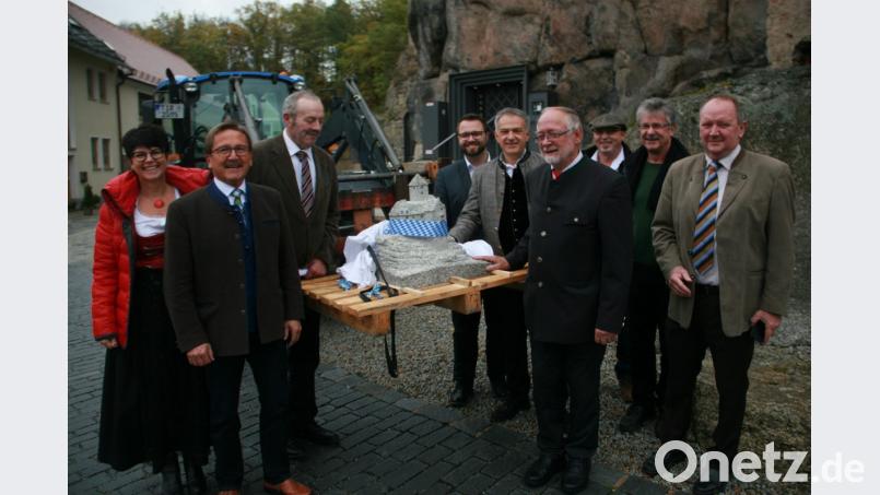 Diese kleine Burg – aus einem Granitblock gefertigt – hat die Marktgemeinde Herbert Bauer (Vierter von rechts) zum Geschenk gemacht. Neben einer Abordnung des Marktgemeinderates gratulieren auch Bürgermeister-Kollegen. Bild: wro