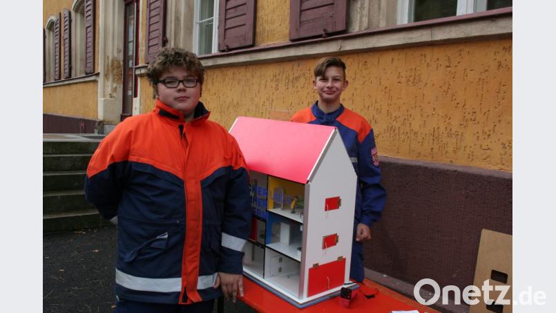 Anhand des Rauchmelderhauses demonstrieren zwei Feuerwehranwärter anschaulich die Funktionsweise eines Rauchmelders bei einem Zimmer- oder Wohnhausbrand. Bild: wfw