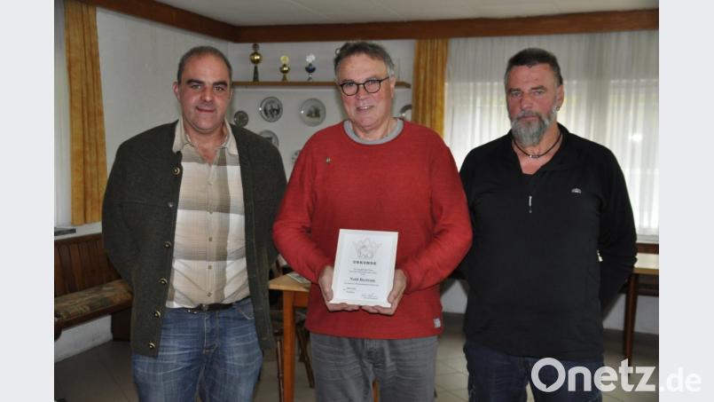 Wolfgang Gründl (links), Vorsitzender der Kulmainer Kleintierzüchter und Kreisvorsitzender Wolfgang Liedl (rechts) überreichen Züchter Bertram Nold (Mitte) eine Urkunde und die goldene Ehrennadel. Bild: ak