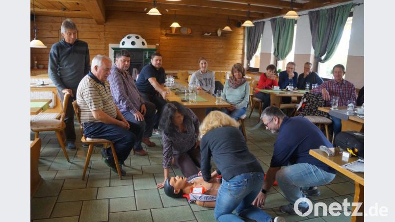 An einer Puppe üben die Viehberger die Herzdruckmassage. Christian Meister (rechts) vom Roten Kreuz weist sie darin ein. Bild: oe