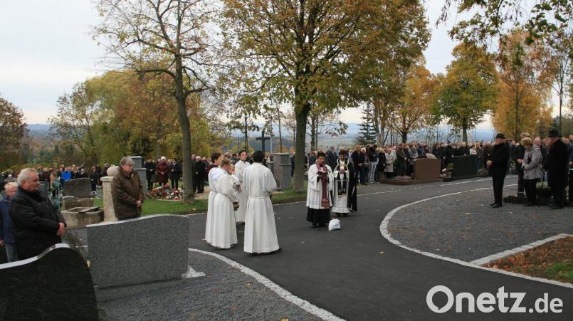 Die Andacht inmitten des Friedhofs leitete Pfarrer Joseph (Zweiter von rechts), der anschließend mit Pater Martin (rechts) auch die Gräber segnete. Bild: wro