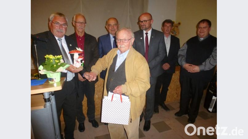 Gerhard Riederer (vorne, rechts) überraschte den Vorsitzenden Anton Schießl (links) mit einem selbstgeschnitzten „Glückspilz“. Bild: mad