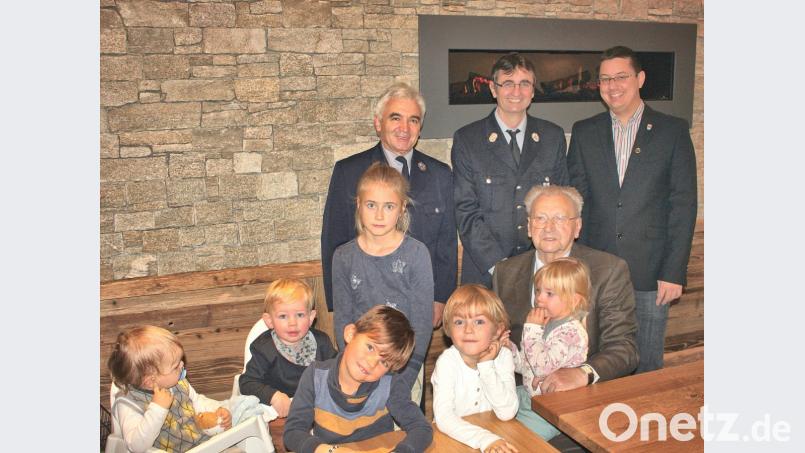 Jubilar Hans Pirner (sitzend, mit einigen Enkeln und Urenkeln), freut sich über die Glückwünsche des Zweiten Bürgermeisters der Gemeinde Illschwang Benjamin Hiltl (rechts), sowie der Abordnung der Feuerwehr Angfeld mit ihrem Vorsitzenden Hans Pickel (links) und Kommandant Klaus Kölbel (Zweiter von links). Bild: no