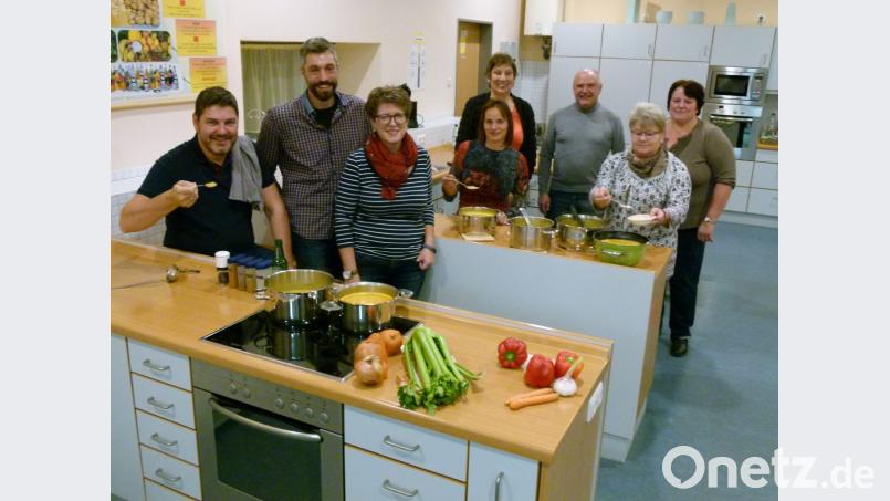 Die „Rote-Linsen-Curry-Suppe“ ist gelungen, die Stimmung vorzüglich: Nach dem Zubereiten unter Leitung von Bürgermeister Peter Lehr (Dritter von rechts) machen sich die Kochabend-Gewinner nun ans Essen. Bild: rn