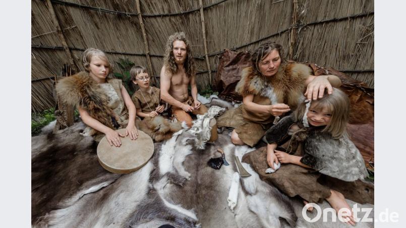 Wie muss man sich das Leben in der Jungsteinzeit vorstellen? Dieses Bild zeigt eine Familie, die an einem Live-Experiment europäischer Steinzeitexperten 2017 in Schleswig Holstein teilnahmen. Bedingungen der Alt-, Mittel- und Jungsteinzeit wurden nachgestellt - ganz offensichtlich mit Ausnahme der Brille. Bild: agentur_dpa