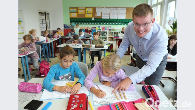 Er ist einer der wenigen Männer, die an Grundschulen unterrichten: Lehrer Johannes Arndt. Hier schaut der stellvertretende Leiter der Hammerwegschule gerade seinen Schüler in der Kombiklasse 2/3 über die Schulter. Bild: Wolfgang Steinbacher