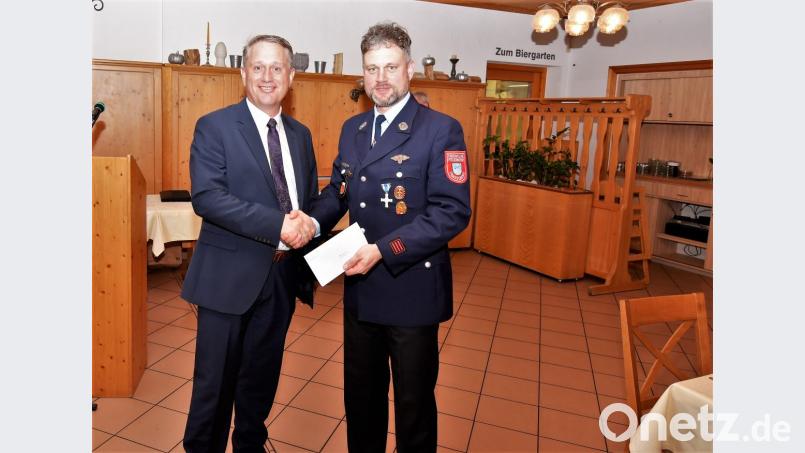 Zweiter Bürgermeister Herrmann Böhm übergibt eine Spende an Christian Beck, den Vorsitzenden des Feuerwehrvereins. Bild: chl