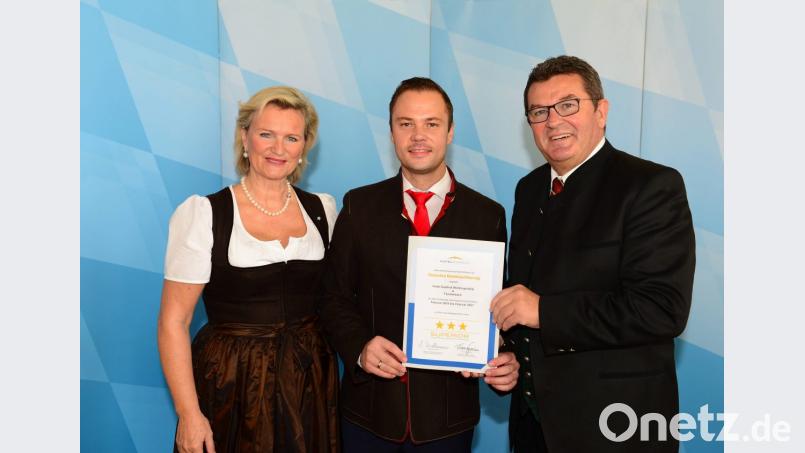 DEHOGA-Präsidentin Angela Inselkammer (links) und Wirtschaftsminister Franz Josef Pschierer (rechts) übergaben die Auszeichnung an Thomas Auerbach vom Hotel Wolfringmühle. Bild: exb