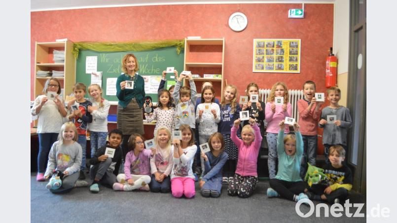 Zusammen mit ihrer Tschechisch-Lehrerin Lenka Uschold präsentieren die Kinder der Klasse 1/2 der Grundschule Schwarzenbach stolz ihr selbst gestaltetes Deutsch-Tschechisches Tiermemory. Bild: myd