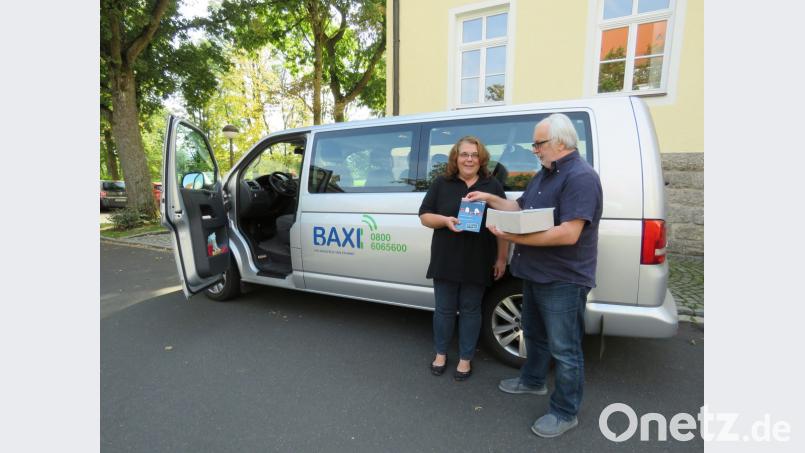 Jetzt geht&#039;s auch elektrisch: &quot;Baxi&quot;-Fahrerin Marion Gradl erhält vom Tirschenreuther ÖPNV-Experten Peter Zimmer Flyer, die über das neue &quot;E-Baxi&quot; informieren. Bild: ubb
