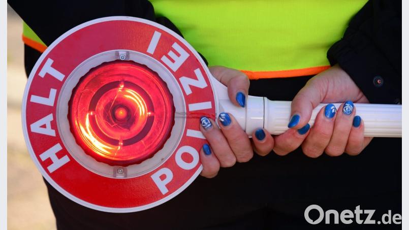 Polizei mit Anhaltekelle. Bild: Martin Schutt/dpa