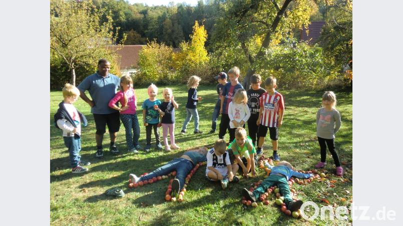 Sichtlich Spaß macht es den Kindern und Pfarrer Moses Gudapati, die Apfelmännchen zu legen. Bild: bas