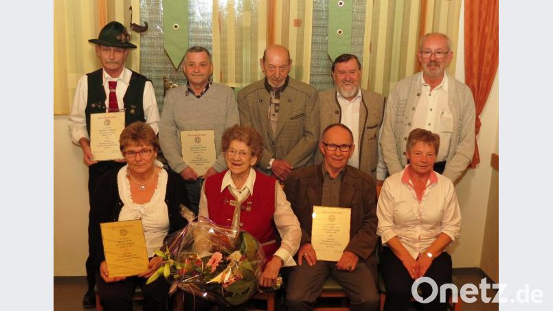 Der Trachtenverein „Almfrieden“ mit Vorsitzenden Herbert Schiller (stehend links) ehrte zur Jahreshauptversammlung langjährige Mitglieder im Kreise der neu gewählten Vorstandschaft. Elsa Binner erhielt für 70 Jahre die einen Blumenstrauß. Bild: Dobmeier